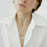 Close-up of silver Fluid Shaped Pendant Necklace worn on woman, ideal for date nights.