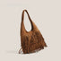 Side profile of the fringe suede hobo bag in a rich camel brown tone.