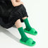 Model wearing a pair of green fuzzy plaid socks, ideal for everyday outfits and sneakers.