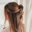 Model wearing a Gentle Curve Hair Claw in brown, ideal for everyday outfits and office looks.