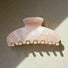 Flat lay of Gentle Curve hair claw with soft glow color, great for everyday.