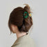 Model wearing a Glossy Cloud Hair Claw in dark green, easy for workdays and special occasions.