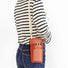 Model carrying a orange polyester crossbody bag , ideal for city walks and gifting.