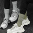 Two models wearing cotton googly eyes socks: one olive green and one grey.