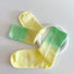 Folded view of Gradient Rainbow Socks in green and yellow, ideal for workouts and commuting.