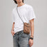 Male model wearing the grid magnetic utility pouch in brown over a plain white t-shirt.