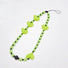 Angled view of Heart Beat Phone Charm with lime green hearts and striped bead.