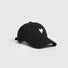 Side angle view of a classic black cotton twill cap featuring white heart embroidery.