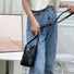 Model carrying a black Hollow Design Woven Leather Crossbody Bag handheld, ideal for city walks and gifting.