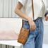 Model carrying a tan Hollow Design Woven Leather Crossbody Bag on shoulder , easy for commuting and weekends.