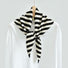 Angled view of the black and white wool striped triangle scarf on a hanger, easy for travel packing and gifting.