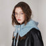 Side profile of the blue knitted balaclava hat styled with a black leather jacket for a chic winter look.