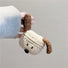 Model Hands holding one ear of the Knitted puppy AirPods case, great for daily use and protection.