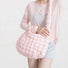Model wearing the soft pink puffy crossbody bag with a light top.