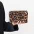 Model holding a brown leopard print makeup bag in hand, ideal for daily makeup essentials.