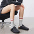 Model wearing a pair of gray cotton knitted socks, ideal for everyday outfits and sneakers.