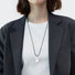 Model wearing silver lustrous drop pendant necklace, minimalist elegant jewelry style