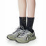 Model wearing a pair of Metallic Tie Dye Slouch Socks in black, easy to pack for travel and errands.