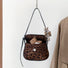 Angled view of Mini Leopard Suede Saddle Bag, great for everyday carry and travel.