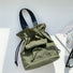 Olive green mini nylon bucket bag with a functional front utility pocket.