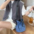 Vibrant blue mini nylon bucket bag worn as a statement shoulder bag.