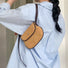 Model carrying the khaki suede saddle bag on her shoulder for an urban look.
