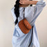 Model styling the tan mini suede bag with a casual outfit.