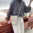 Model carrying a white crossbody bag on the shoulder, easy for commuting and weekends.