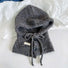 A mink brown knitted balaclava hat with a functional button and drawstring bow.