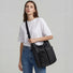 Model wearing the multi-pocket nylon crossbody bag in black, demonstrating the adjustable fit.