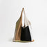 Front view of the earthy neutral colorway crochet tote bag with beige, warm brown, and black knit panels.