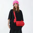 Model carrying a red nylon crossbody bag , easy for commuting and weekends.