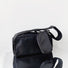 Flat lay of Nylon Brick Cassette Crossbody Bag in black, great for everyday carry and travel.