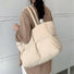 Back view of the apricot padded tote bag worn on the shoulder.