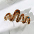 Angled view of Painted Wave Hair Claw in brown, ideal for quick updos and ponytails.