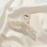 Detailed view of the cross-over design pearl hair clip; showcasing the premium architecture.