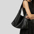 Side view of the black pebble leather bag being worn on the shoulder.