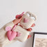 Model Hands holding two pink heart airpods case covers, one open and one closed.