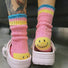 Vibrant pink knitted socks with a smile pattern, perfect for cozy dressing.