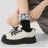 Model wearing a pair of Plaid Fuzzy Socks in black, great for daily wear and lounging.