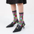 Model wearing a pair of Patchwork Socks in gray, easy to pack for travel and errands.