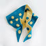 Flatlay view of blue and cream yellow reversible polka dot knit scarf.
