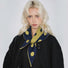 Model wearing navy blue and mustard yellow polka dot knit triangle scarf.