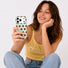 Lifestyle shot of a model holding the mint silicone phone cover with brown dots.