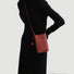 Model carrying a red Polycolor hanging ball leather bag on the shoulder, ideal for city walks and gifting.