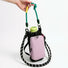 A hand holding the green contrast utility rope handle of the pastel pink water bottle bag.