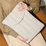 Model carrying the light grey puffy laptop sleeve as a stylish protective case.
