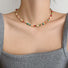 Model wearing the vibrant rainbow beaded necklace styled with a grey summer top