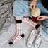 Model wearing a pair of red checkered cotton socks, ideal for everyday outfits and sneakers; for office.