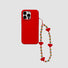 Red silicone iPhone case with a beaded rainbow heart charm. Vibrant Indie aesthetic accessory.